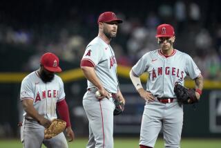 Los Angeles Angels relief pitcher Hunter Strickland, center, pauses on the mound.