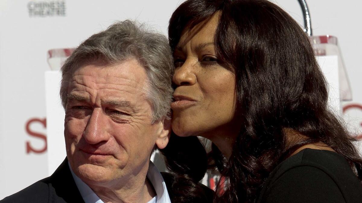 Robert De Niro gets a kiss from wife Grace Hightower after a handprint ceremony in Hollywood in 2013.