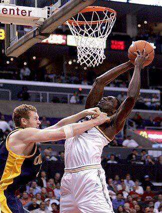 UCLA Bruin Alfred Aboya goes to the basket despite being defended by Cal Bear Taylor Harrison.