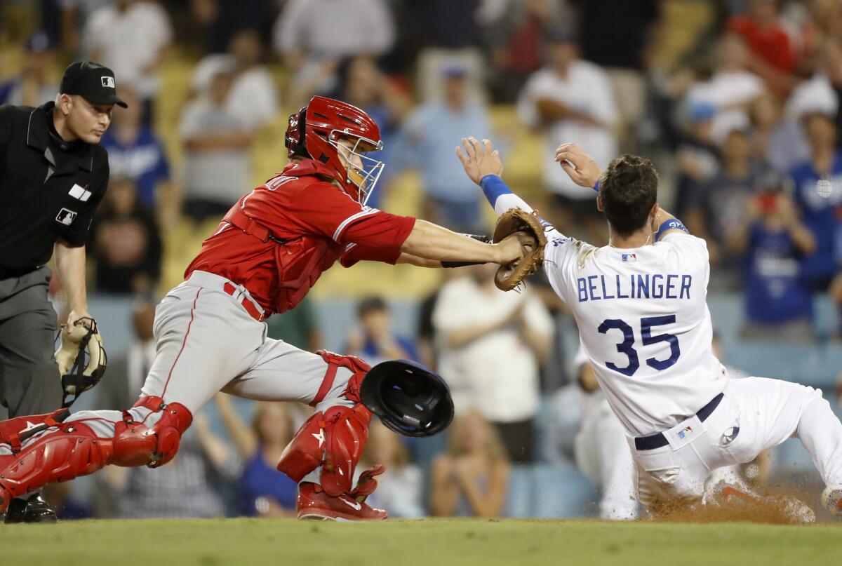 Angels catcher Dustin Garneau puts a tag on Dodgers right fielder Cody Bellinger for the final out of the game on Tuesday at Dodger Stadium.