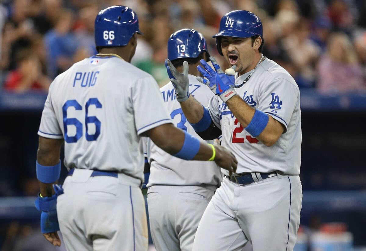 Adrian Gonzalez, right, is congratulated by Yasiel Puig after hitting a three-run home run during the eighth inning of the Dodgers' 10-9 victory over the Toronto Blue Jays on Tuesday.