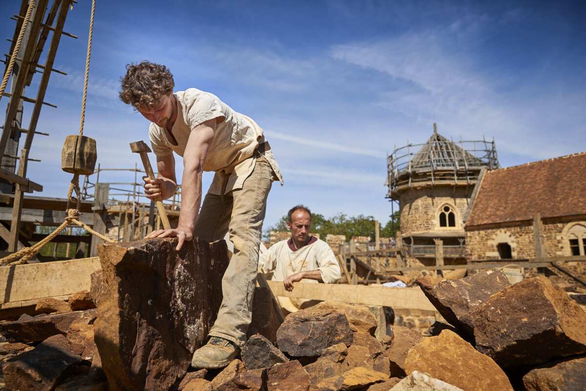 Masons work on building two Gothic arches at Guedelon medieval castle project. Since it opened in 1998, Guedelon has been built by trial and error using period techniques and tools,