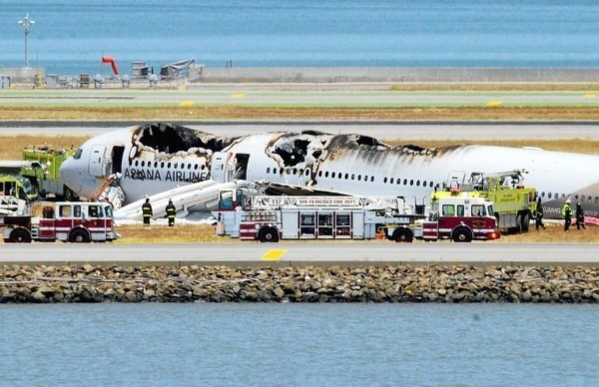 The wreckage of an Asiana Airlines jet rests on a runway at San Francisco International Airport after a July 6 crash landing. Officials say no charges will be filed against first responders, including the driver of a fire rig that ran over and killed a Chinese teen who was a passenger on the plane.