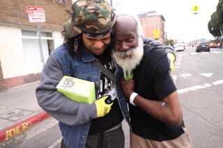 Chef Clive Jackson, right, receives a hug from Community Ambassador Samson Tafolo.