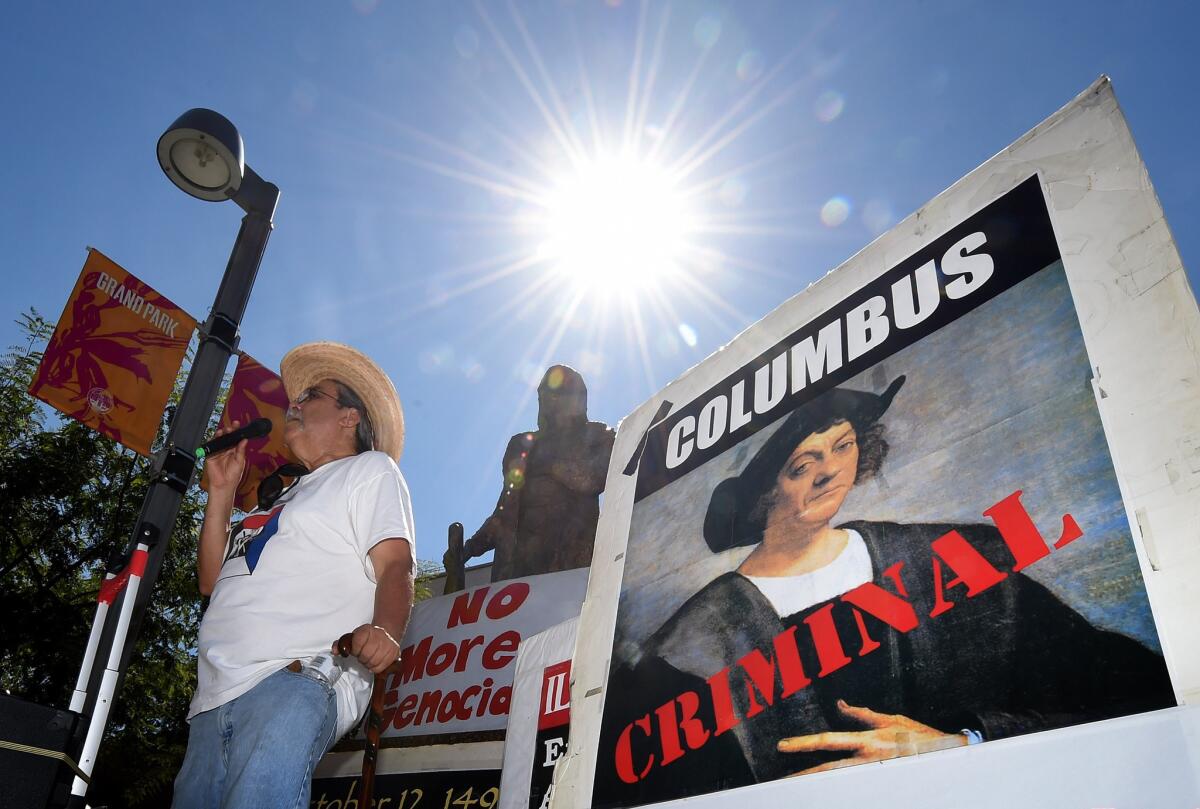 Olin Tezcatlipoca from the Mexica Movement speaks to demonstrators in front of a statue of Christopher Columbus in Los Angeles' Grand Park.