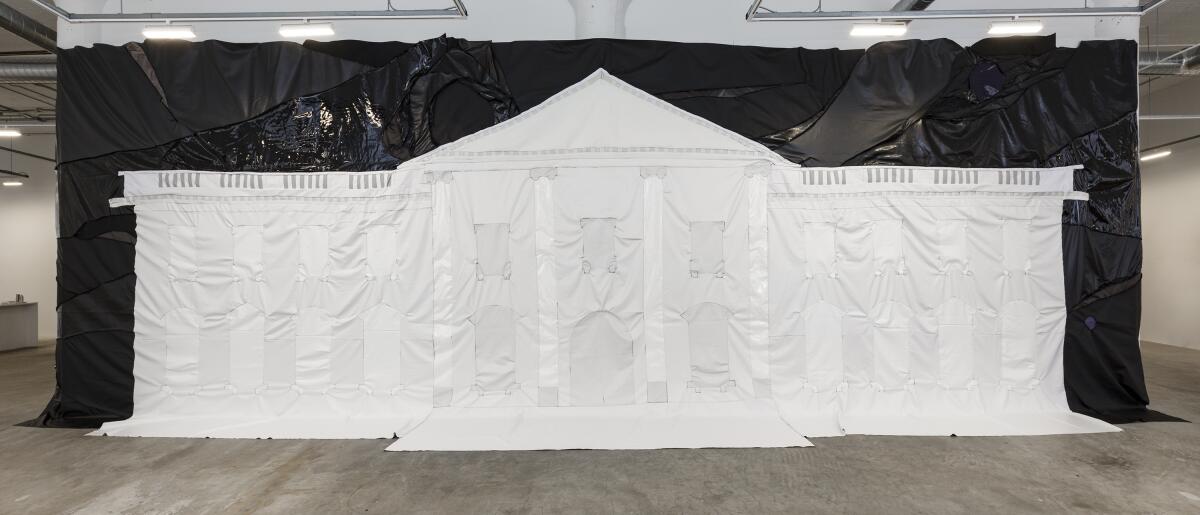 A wide shot shows the facade of the U.S. White House made out of thread and black and white pieces of vinyl.