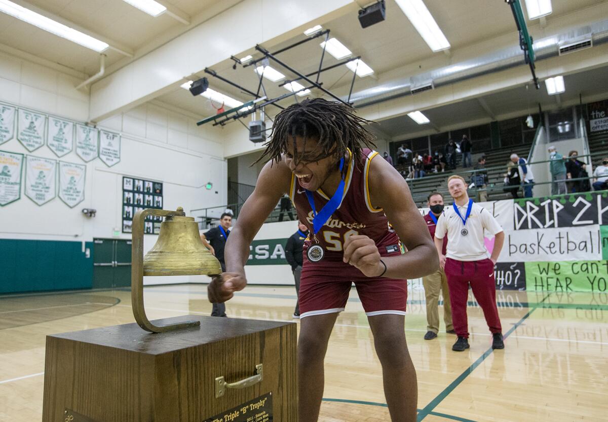 Estancia's Lewis Tate rings the bell following the second Battle for the Bell boys' basketball game on Wednesday.