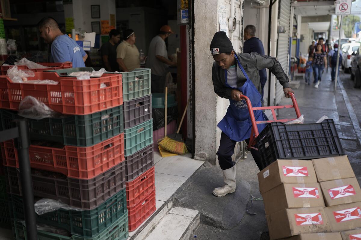 Un trabajador migrante haitiano estiba cajas en una tienda 