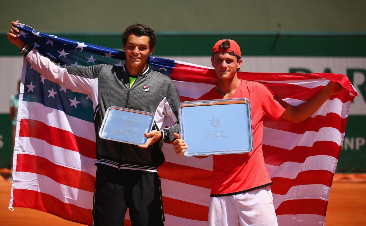 Runner up Taylor Fritz (left) and winner Tommy Paul pose with their trophies after their French Open Boys' Singles Final match in June.