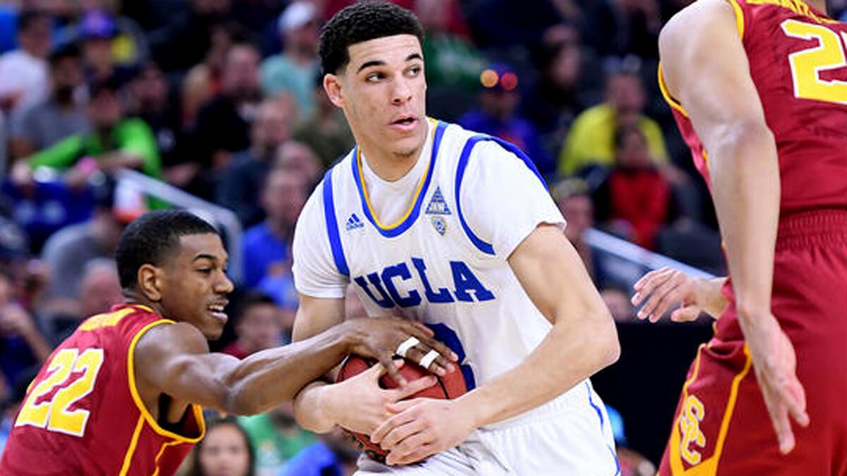 UCLA guard Lonzo Ball picks up a loose ball in front of USC guard De'Anthony Melton during the first half.