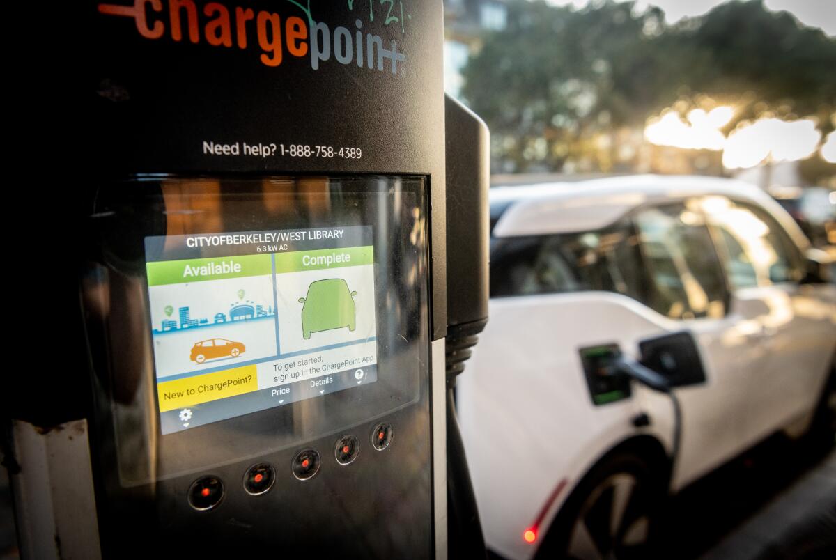 An electric vehicle 'refuels' at a charging station at a   Berkeley library branch in 2021.