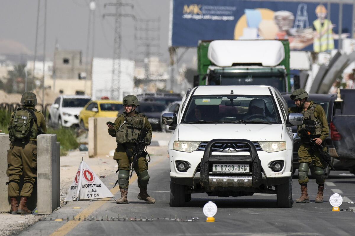 Israeli soldiers search a car.