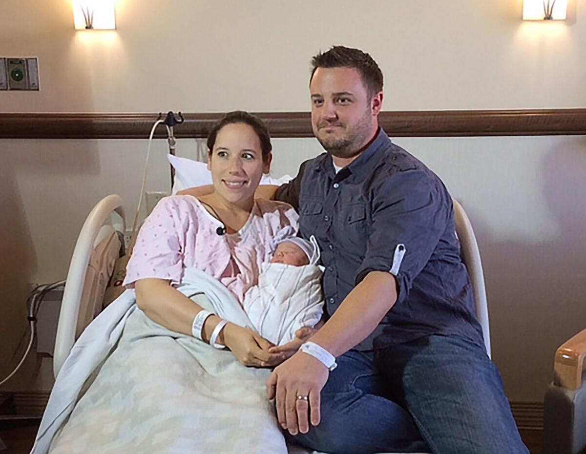 Katherine and Keith Arthur pose with their baby girl, Colette, at the hospital Wednesday after delivering her at home with help from a 911 dispatcher.
