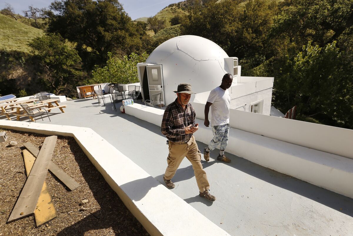 Documentarian George Szabo, left, and homeless activist Abiyah JuJuMane visit a prototype for a dome residence on Wayne Fishback's land.