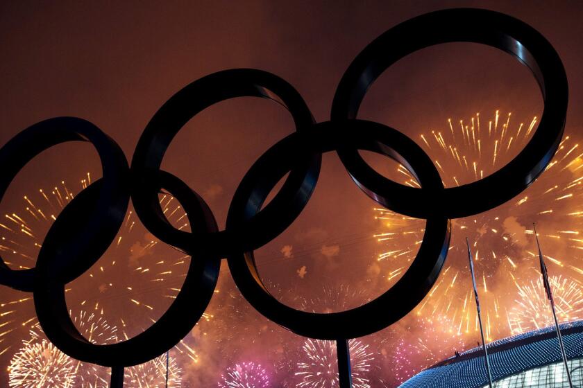 The Olympic rings are silhouetted as fireworks light up the night sky during the closing ceremonies of the 2014 Sochi Olympic Games.