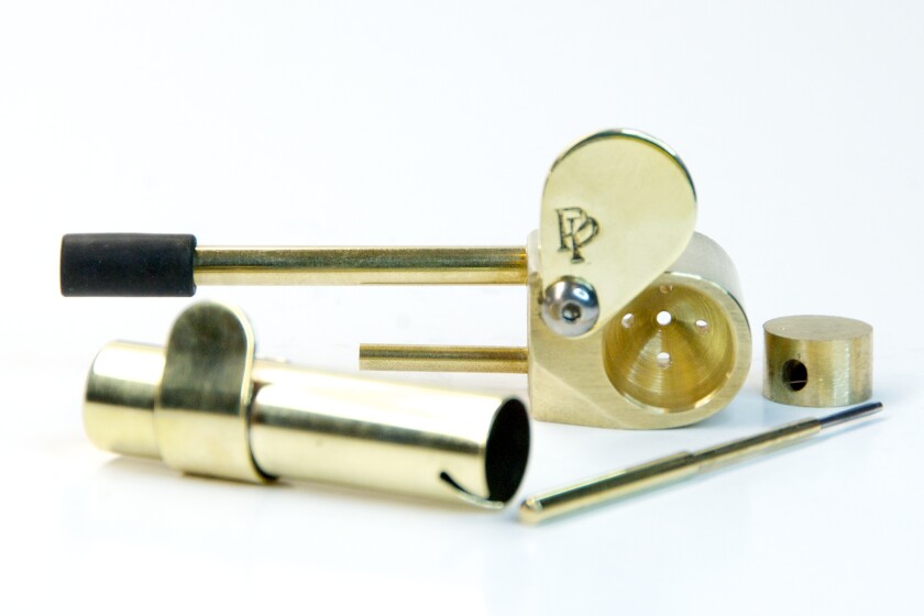 A disassembled brass smoking pipe