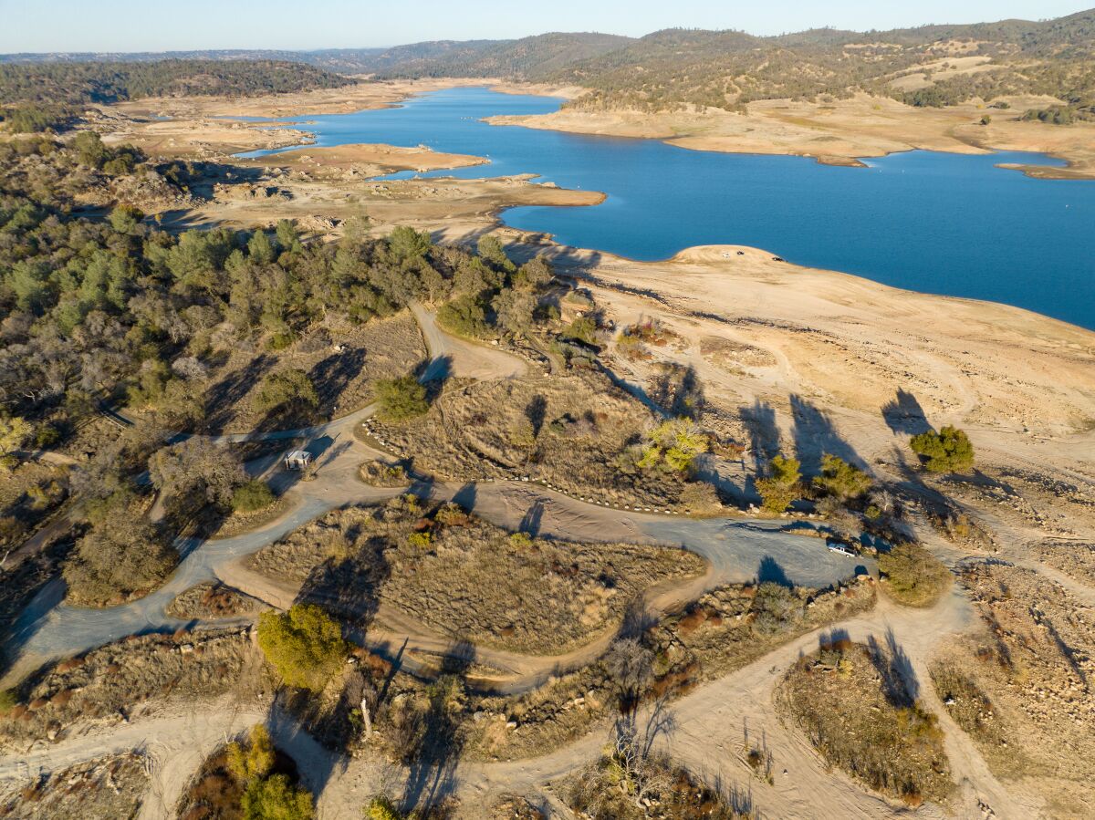 An aerial view of a lake with a wide dry-land margin. 