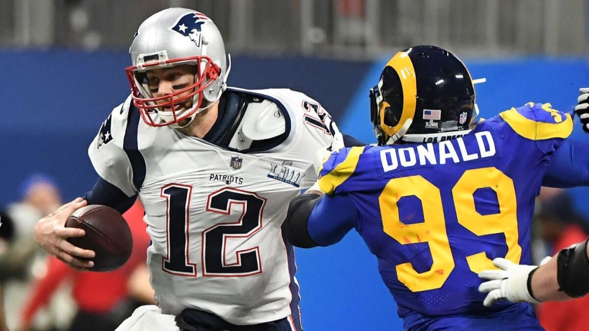 Rams defensive tackle Aaron Donald tries to sack Patriots quarterback Tom Brady during the first half.