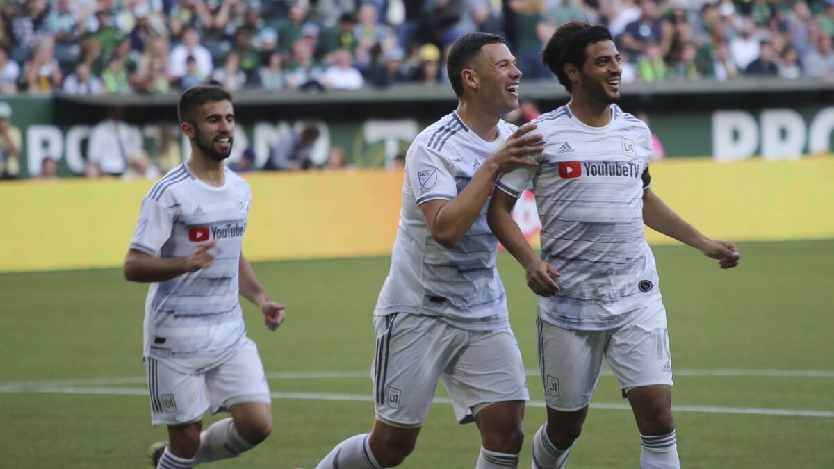 LAFC's Carlos Vela, right, smiles after a goal during a match against the Portland Timbers on Saturday in Portland, Ore.