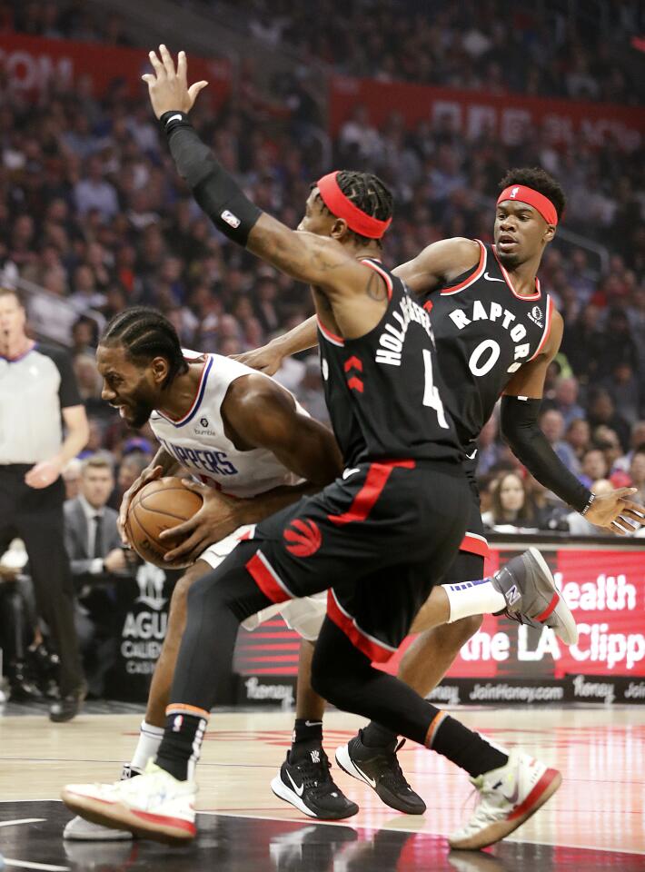 LOS ANGELES, CALIF. - NOV. 11, 2019. Clippers forward Kawhi Leonard splits the defnse of Raptors Rondae Hollis-Jefferson and Terence Dsvis II in the first quarter at Staples Center in Los Angeles on Monday night, Nov. 11, 2019. (Luis Sinco/Los Angeles Times)