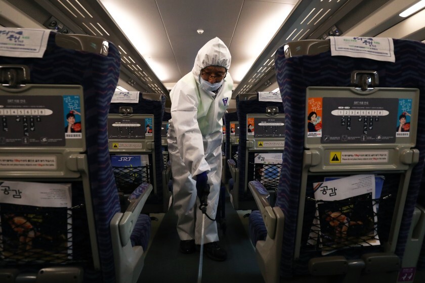 A worker wearing protective gears sprays antiseptic inside a train in Seoul.