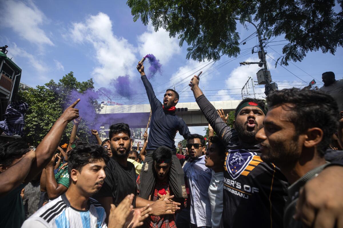Protesters raise their arms and shout in celebration in Dhaka, Bangladesh.