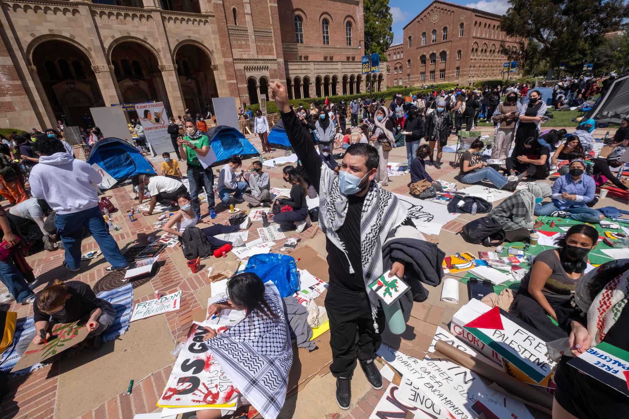 A pro-Palestine protester raises his fist at an encampment set up on the campus of UCLA.