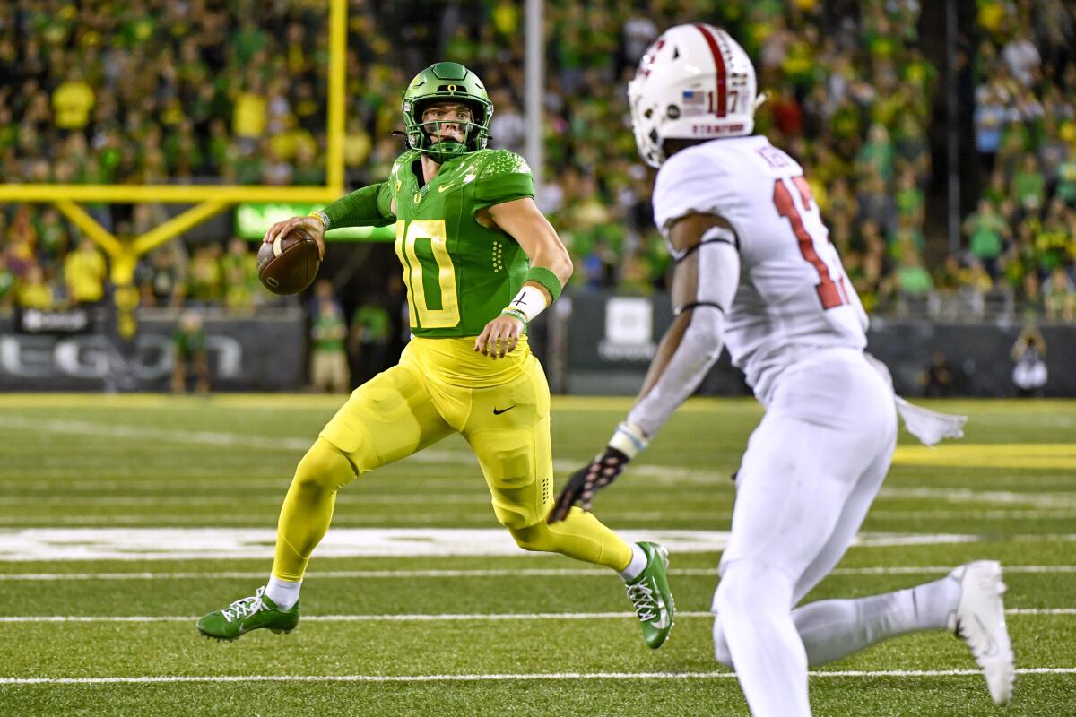 Oregon quarterback Bo Nix (10) looks for a receiver as Stanford cornerback Kyu Blu Kelly (17) defends during the first half of an NCAA college football game Saturday, Oct. 1, 2022, in Eugene, Ore. (AP Photo/Andy Nelson)