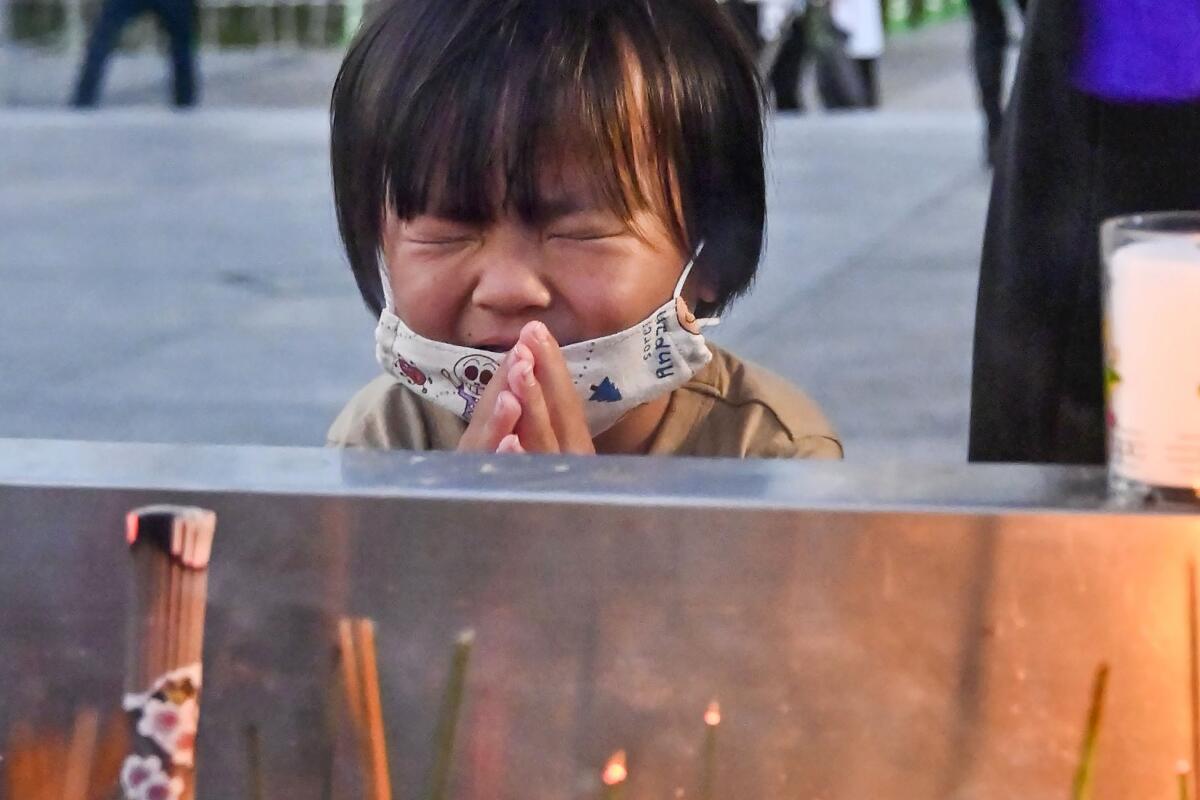 A child praying at a cenotaph