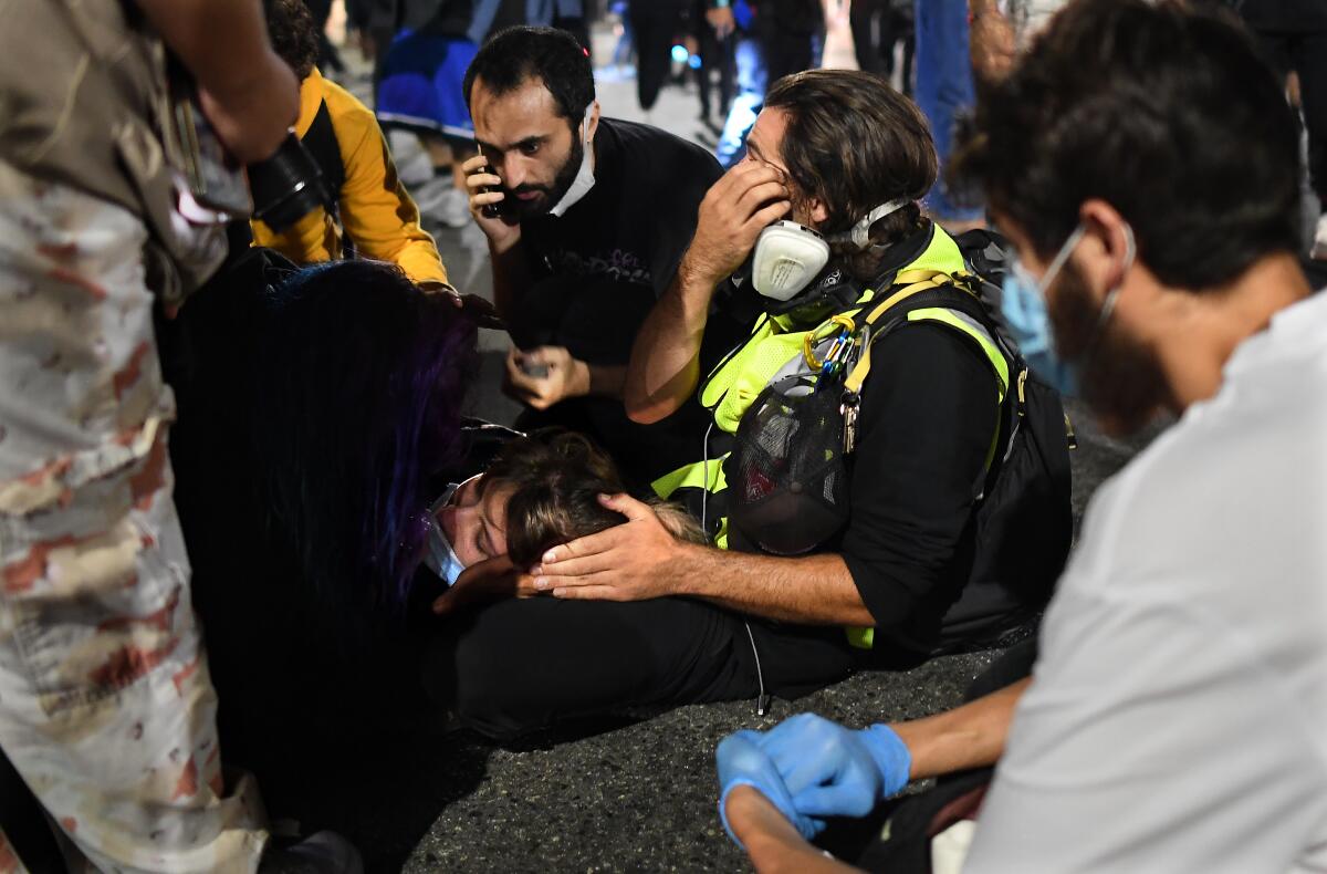 Paramedics help a protester who was hit by a vehicle on Sunset Boulevard in Hollywood. (Los Angeles Times/Wally Skalij)