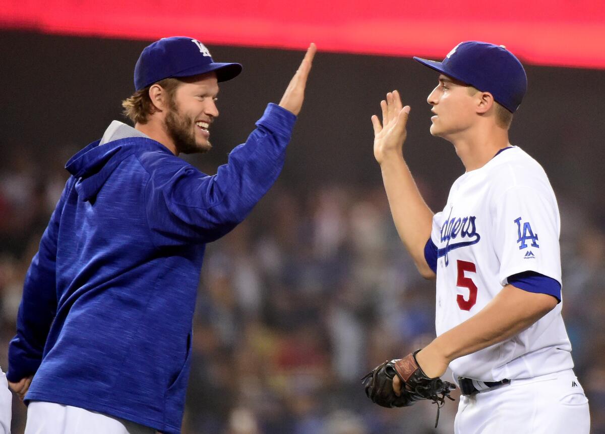 Dodgers shortstop Corey Seager (5) celebrates his three home run night with pitcher Clayton Kershaw following a 4-2 victory over the Atlanta Braves on June 3.