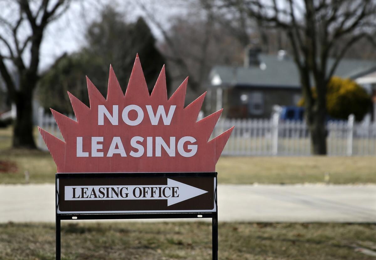 A "now leasing" sign with a red starburst on top of a white arrow that says "leasing office"