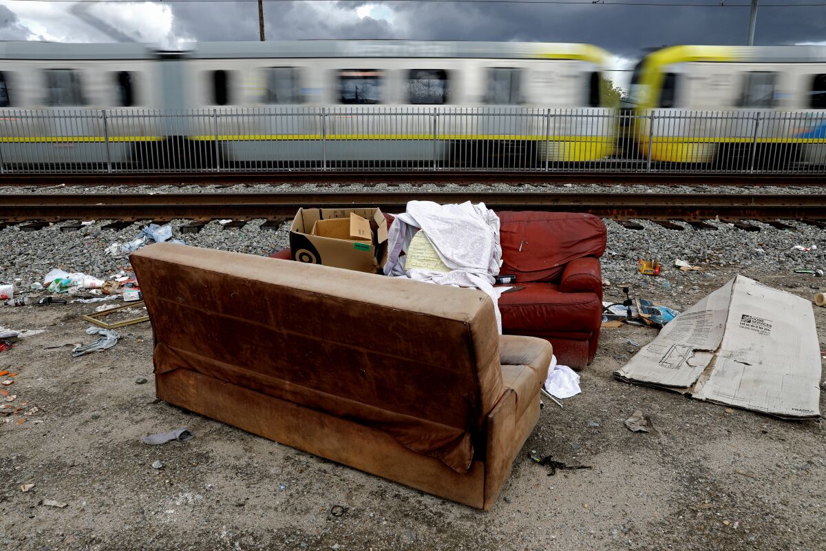 Furniture and trash are dumped next to the train tracks along Grandee Avenue in Watts.