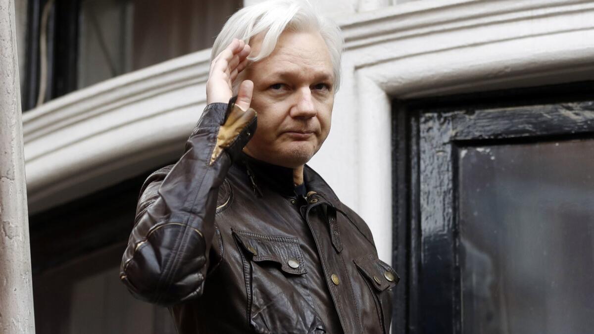 WikiLeaks founder Julian Assange greets supporters from a balcony of the Ecuadorean Embassy in London in 2013.