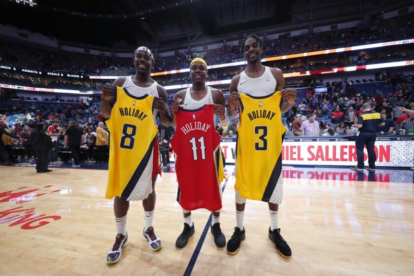 New Orleans Pelicans guard Jrue Holiday, left, swaps jerseys with his brothers Indiana Pacers guard Aaron Holiday, center, and Pacers forward Justin Holiday, right, after an NBA basketball game in New Orleans, Saturday, Dec. 28, 2019. The Pelicans won 120-98. (AP Photo/Gerald Herbert)