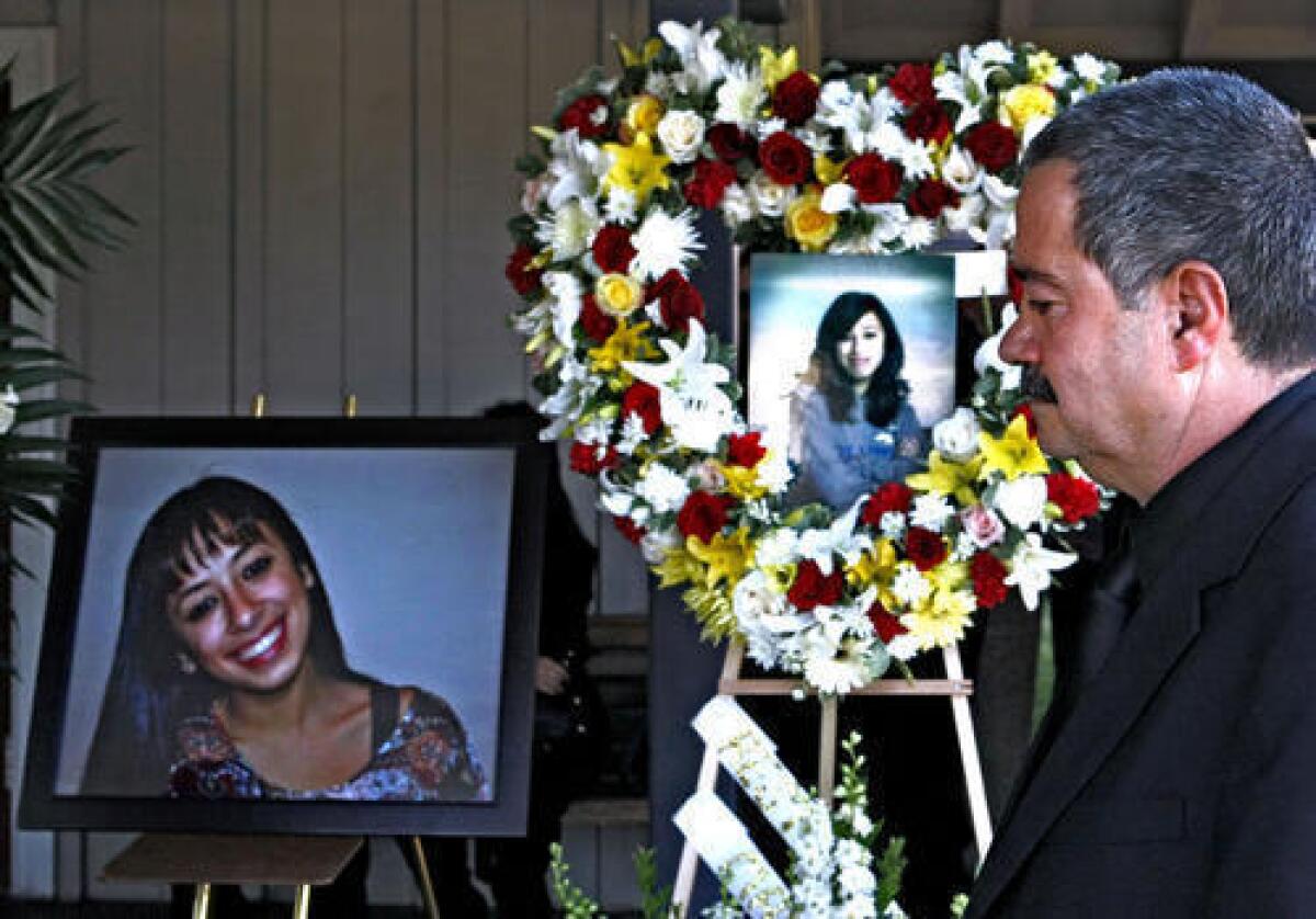 Family member passes by photos of Malak Hariri during funeral service at Pierce Brothers Valhalla Memorial Park in North Hollywood on Friday, Oct. 4, 2013. About 400 people came to pay their respects art the funeral. Hariri was one of five people who died in a single vehicle car crash last Saturday in Burbank.