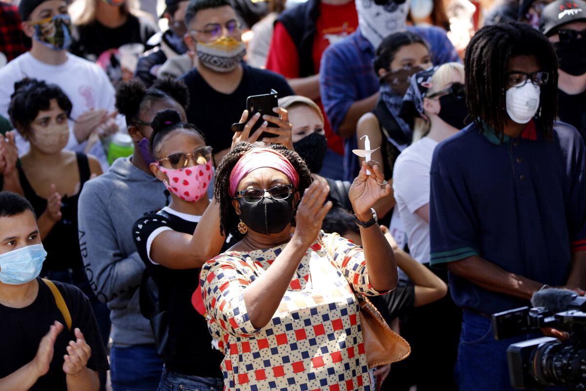 Attendees clap during the Juneteenth event at Sasscer Park in Santa Ana on Friday.