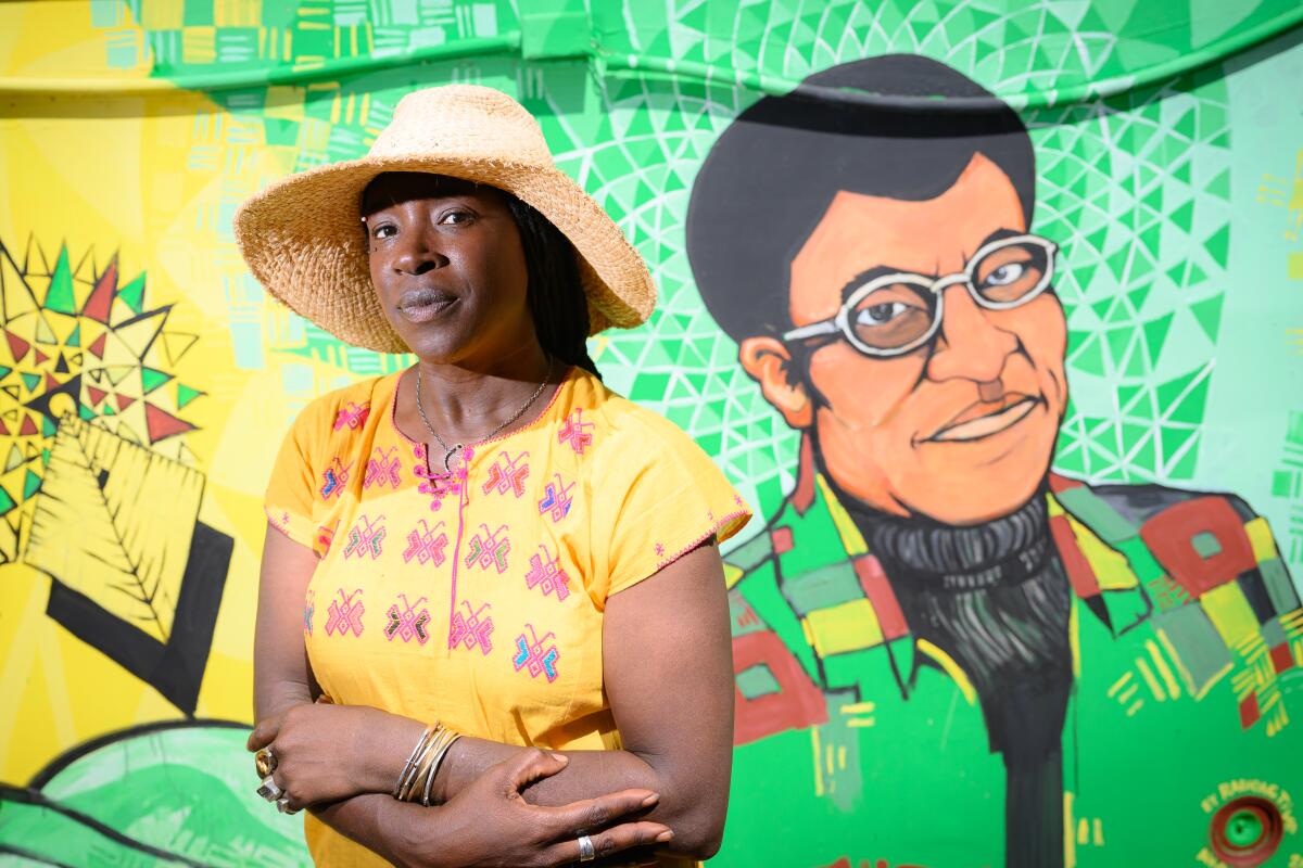 Farm founder Pandora Thomas stands near a mural depicting Octavia Butler at EarthSEED Farm