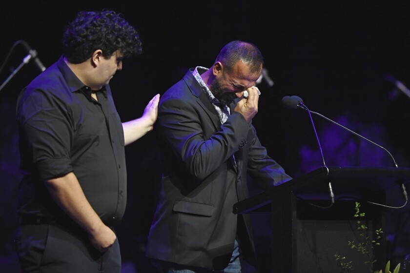 Temel Atacocugu, right, who survived being shot nine times during the attack on the Al Noor mosque, cries as he speaks at a National Remembrance Service, Saturday, March 13, 2021, in Christchurch, New Zealand. The service marks the second anniversary of a shooting massacre in which 51 worshippers were killed at two Christchurch mosques by a white supremacist. (Kai Schwoerer/Pool via AP)