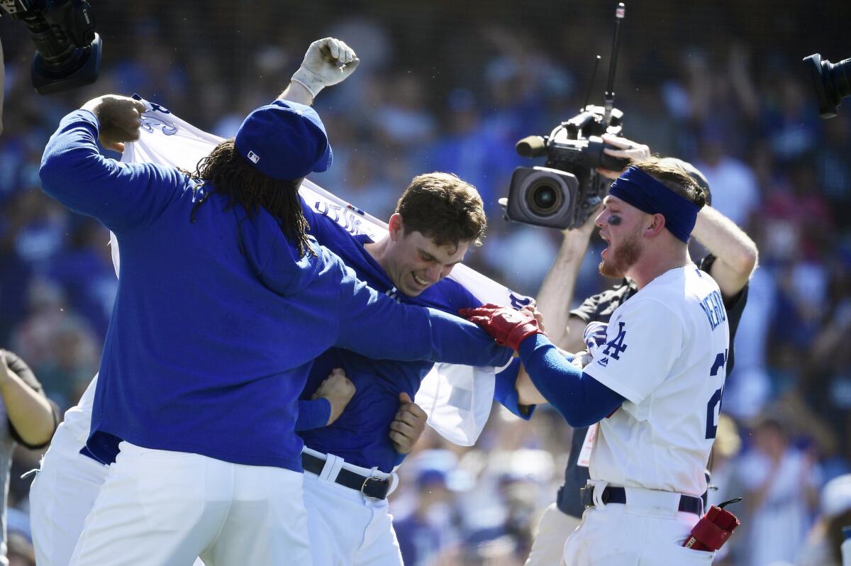 From left, Kenley Jansen, Will Smith and Alex Verdugo celebrate the rookie Smith's three-run, walk-off homer in the ninth inning that gave the Dodgers a 6-3 win Sunday over the Rockies.