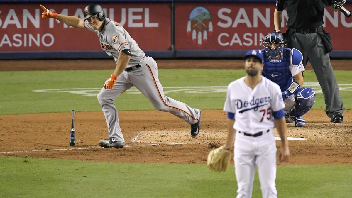 San Francisco Giants' Nick Hundley, left, celebrates as he hits a two-RBI single as Dodgers relief pitcher Scott Alexander, center, watches along with catcher Austin Barnes during the ninth inning.