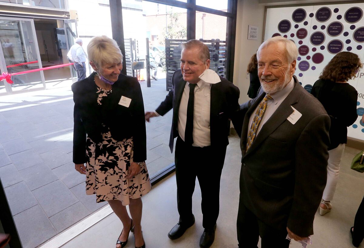 Andy Bales, center, greets donors during the opening of Angeles House