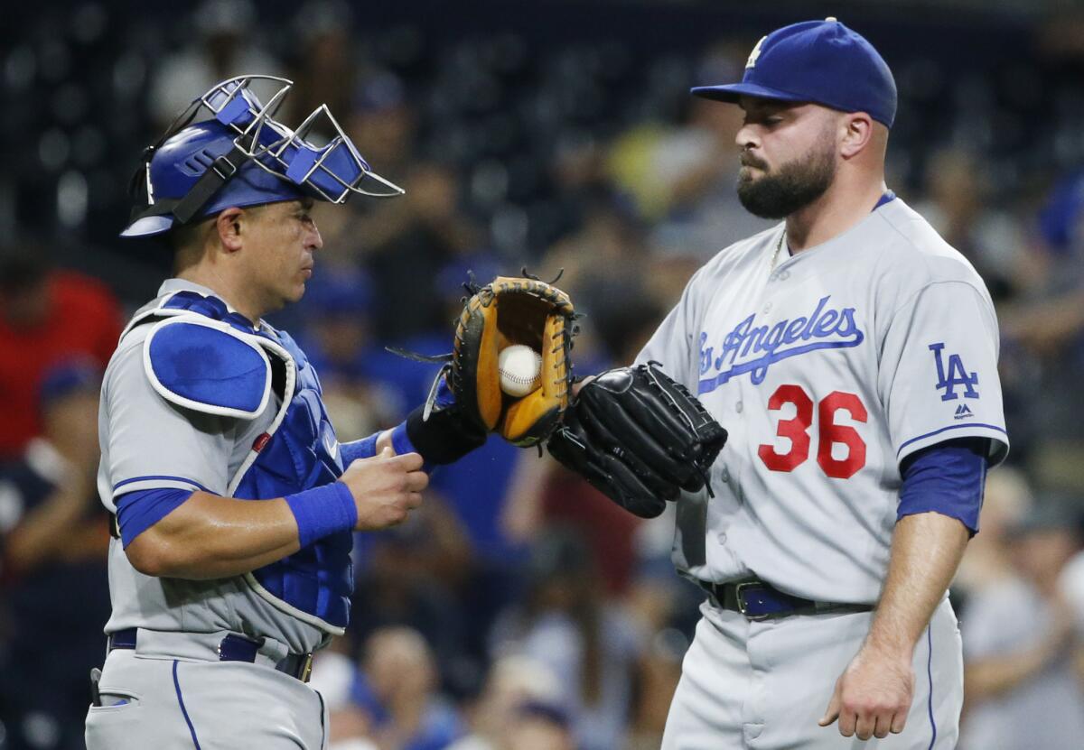 Dodgers relief pitcher Adam Liberatore and catcher Carlos Ruiz bump gloves after the Dodgers' 9-4 victory over the San Diego Padres on Sept. 29.