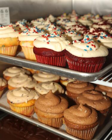 An array of muffins on metal trays at That 1 Bakery