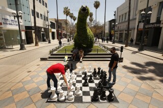 Young Latino and Black people have the lowest rate of
COVID-19 vaccination in L.A. County, new data show 3 SANTA MONICA, CA - MAY 04: Jeremy Canchola, left, visiting from Ohio plays chess with his uncle Alex Rodriguez on the Third Street Promenade in Santa Monica on Tuesday May 4, 2021 as Los Angeles County continues to rebound dramatically from a deadly winter COVID-19 surge, and with vaccinations continuing at a rapid pace there's increasing certainty that public health officials will move the county (and its many businesses, large and small) into the state's least restrictive reopening tier this week. Third Street Promenade on Tuesday, May 4, 2021 in Santa Monica, CA. (Al Seib / Los Angeles Times).