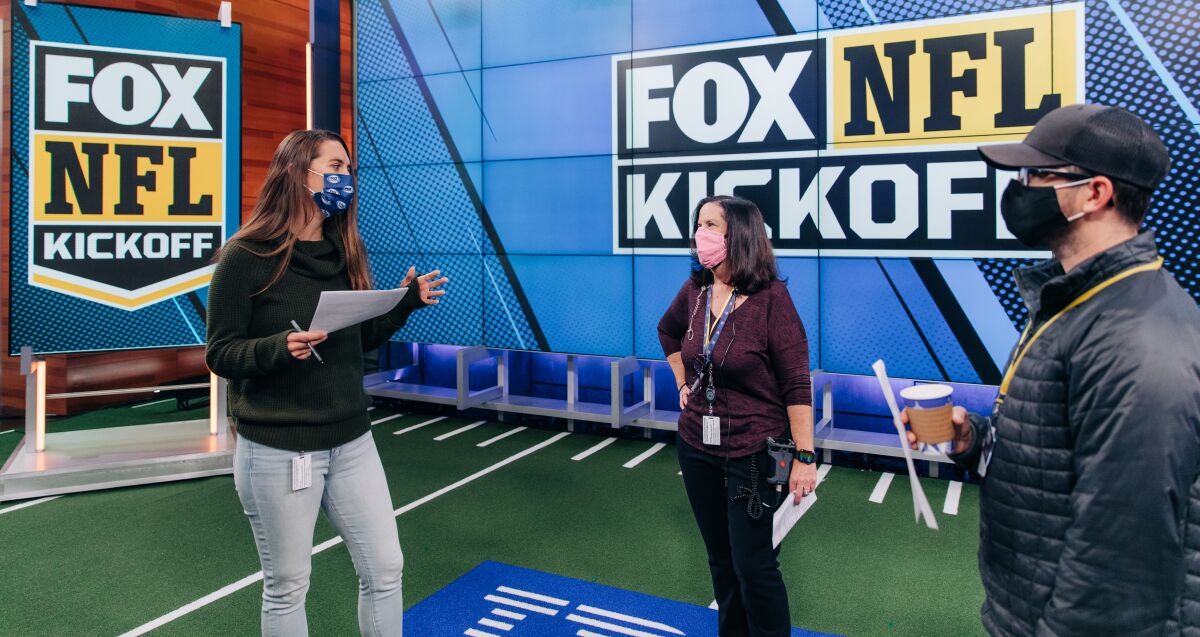 "Fox NFL Kickoff" director Courtney Stockmal, left, speaks to other producers in the show's studio.
