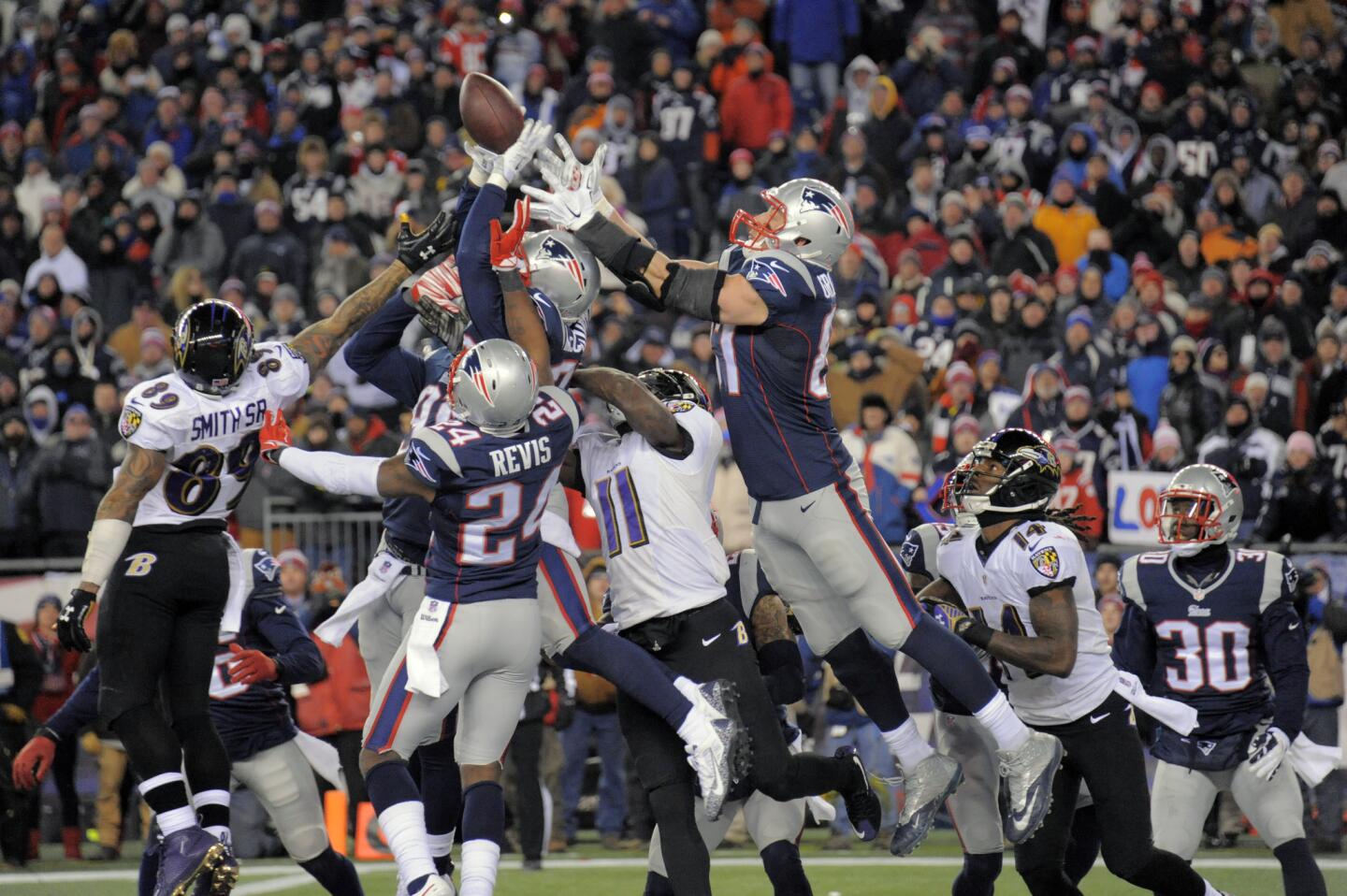 Ravens wide receiver Steve Smith stretches backward in vain as the New England Patriots knock the ball clear on a last-ditch pass from Ravens quarterback Joe Flacco.