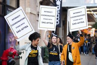 Three women walking down the street, carrying signs that say, 'Intimacy coordinators stand with SAG-AFTRA'