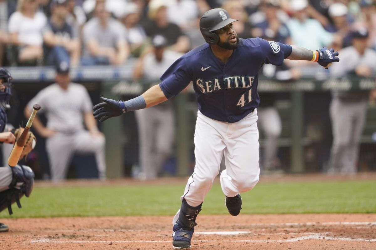Seattle Mariners' Carlos Santana tosses his bat after hitting a two-run home run against the New York Yankees during the seventh inning of a baseball game, Wednesday, Aug. 10, 2022, in Seattle. (AP Photo/Ted S. Warren)
