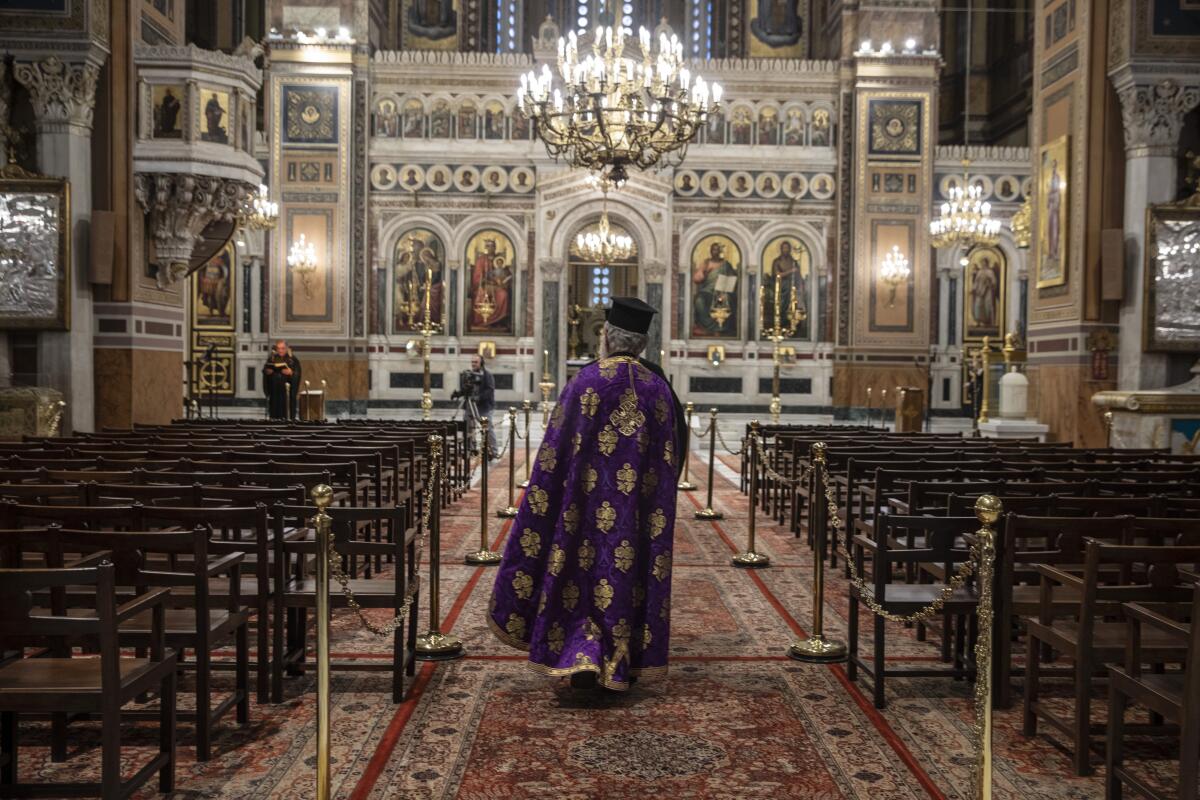 A priest takes part in a Holy Monday ceremony held without worshipers at the Athens Cathedral during Greece's coronavirus lockdown.